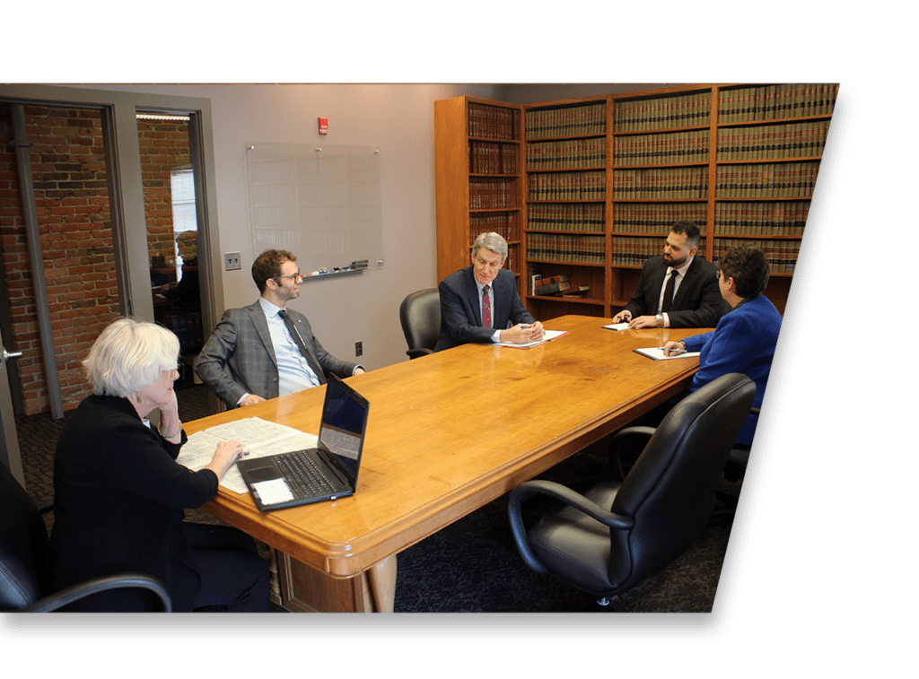Group of legal professional team members talking in an office setting.